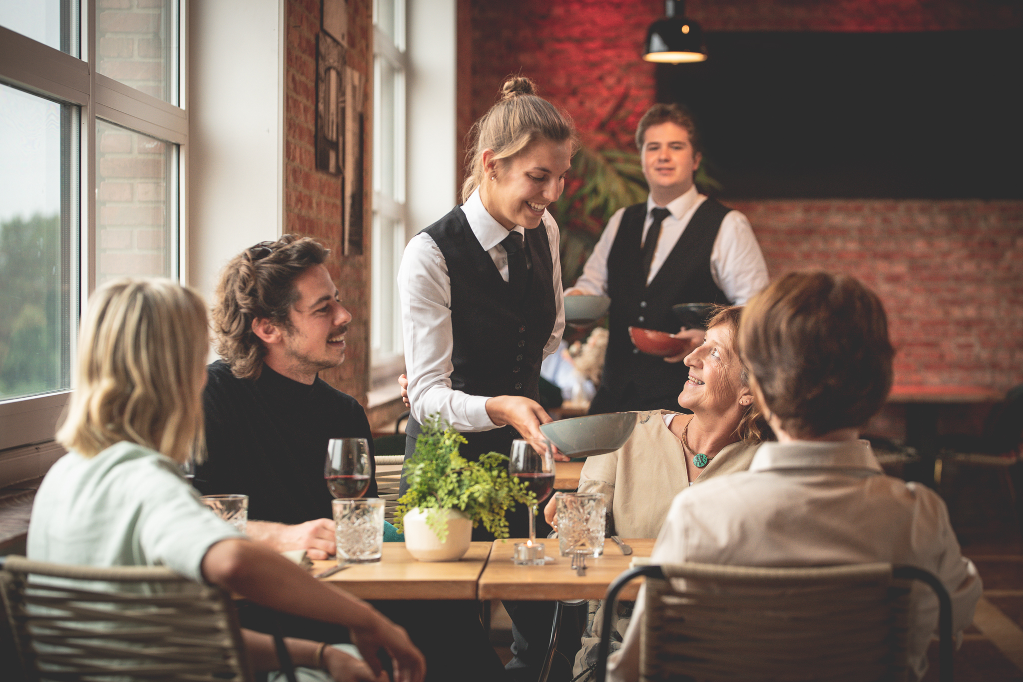 Ober bedient tafel van vier